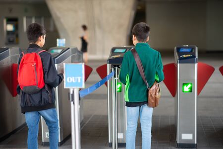 Little boy buying electric ticket and walking in the public skytrain station with family