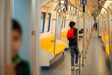 Little boy buying electric ticket and walking in the public sky train station with family 
