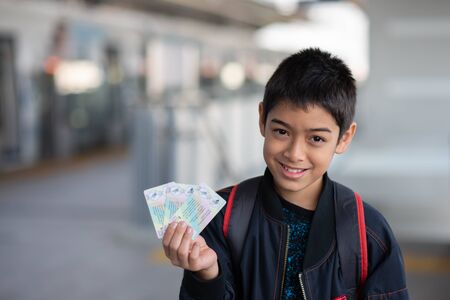 Little boy buying electric ticket and walking in the public sky train station with family