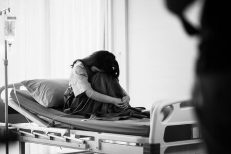 Young Asian patient desperate for serious disease sitting in hostpitalの写真素材