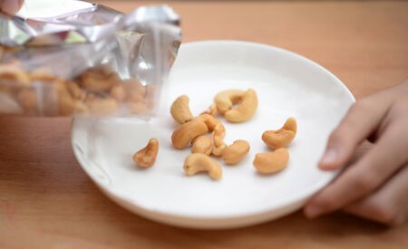 Little boys eating cashew nut healthy snack timeの写真素材