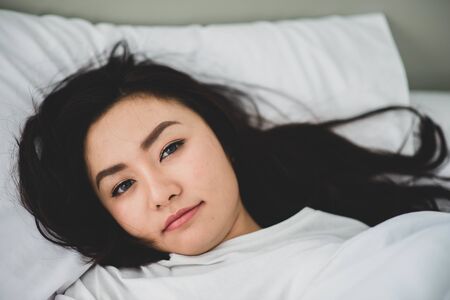 Asain teenager woman just wake up in the morning in the bedroomの写真素材
