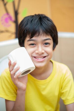 Little boy teen use tissue paper clean in toiletの写真素材