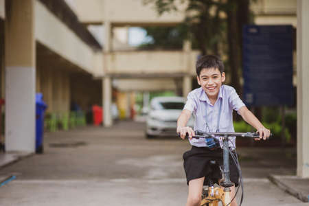 Student boy riding bicycle at school