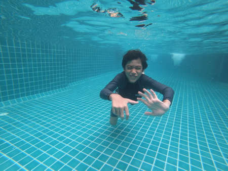 Little boy having fun playing underwater in the pool happy smileの写真素材