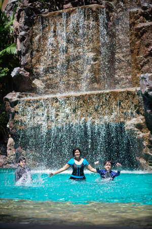 Happy family at water park on vacationの写真素材