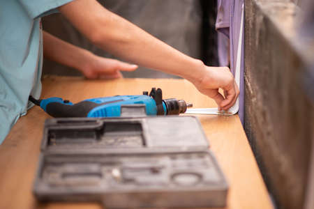 Boy teenager use screwdriver fix wood tableの写真素材