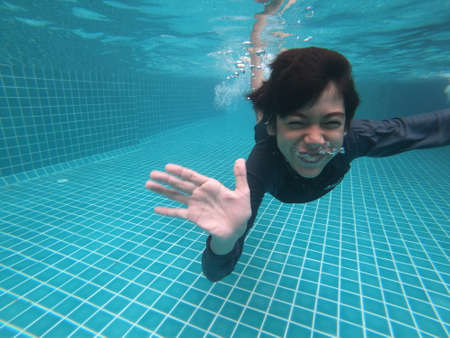 Little boy having fun playing underwater in the pool happy smileの写真素材