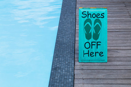No shoes sign by the swimming pool on the wooden floor in green colorの写真素材