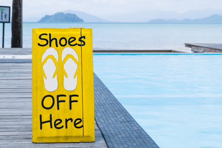 No shoes sign by the swimming pool on the wooden floor in yellow colorのeditorial素材