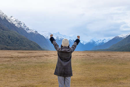 Young Asian traveler celebrating success at Eglinton Valley, Te anua, South Island, New Zealandの写真素材