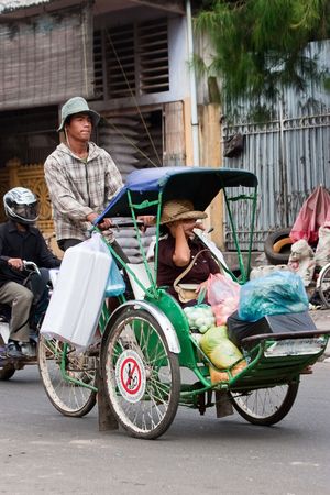 Phnom Penh, Cambodia, January 2, 2008, Cyclo driver peddling his customer and her shopping.のeditorial素材