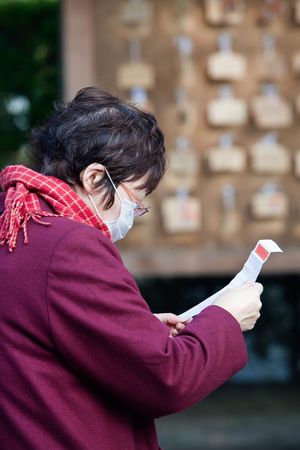 Kagoshima City, Japan, January 2, 2010. A Japanese woman reading an omikuji paper fortune at a...