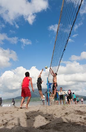 Kagoshima City, Japan, July 1, 2007. A male volleyball player jumps to spike at the Iso Beach beach volleyball competition in Kagoshima City. Active volcano Sakurajima is in the background.のeditorial素材
