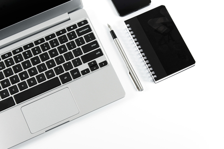 Elegant laptop and pen with notebook isolated on white backgroundの写真素材