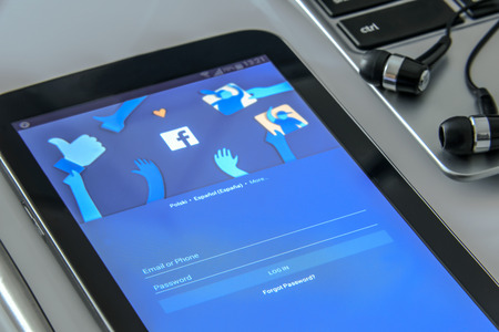 Krynica Poland - November 03, 2016: Facebook app in a mobile phone, close to a laptop. Facebook is one of the most popular social media service app on the world.のeditorial素材