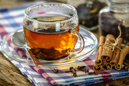 Natural and aromatic cup of tea with cinnamon and cloves in vintage styleの写真素材