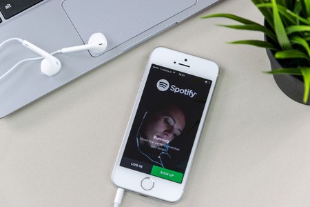 Krynica, Poland - February 02, 2017: Spotify app on iPhone SE screen close to a laptop. Spotify is...