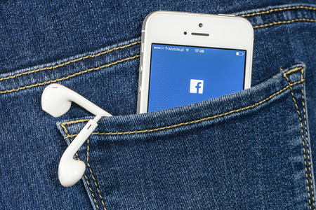 Krynica, Poland - February 02, 2017: Facebok app on iPhone SE screen in blue jeans pocket. Facebook is one of the most popular social media service app on the world.のeditorial素材