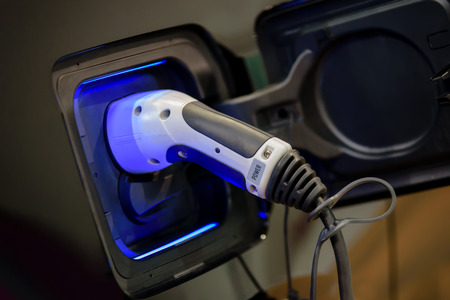Power supply plugged into an electric car during charging.の写真素材