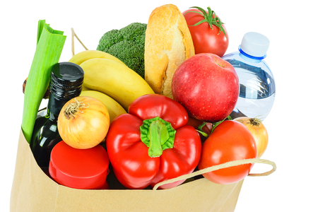 Grocery shopping concept image - Eco friendly paper shopping bag filled with various food products isolated on a white backgroundの写真素材