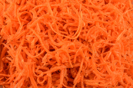 Healthy food background - grated carrot in close-up as a textureの写真素材