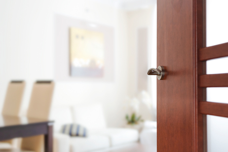 Blurred view through opened wooden door to a modern living room or apartment interior (copy space).の写真素材