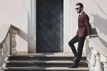 Elegant fashionable man in black sunglasses posing outdoor on the stairs (copy space).の写真素材