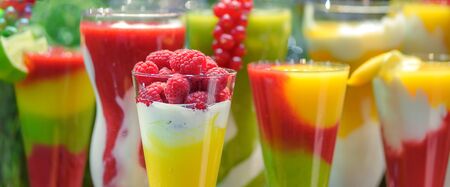 Wide advertisement banner of various fresh fruit drinks in glasses with raspberries smoothie on the foregroundの写真素材