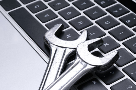 Computer repair service and IT industry support concept  - steel metal wrenches on a laptop keyboard in close-upの写真素材