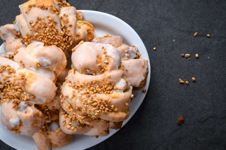 Tasty traditional polish croissants  - Croissant of Saint Martin (Rogal Swietomarcinski) with white poppy seeds and nuts on a dark slate stoneの写真素材