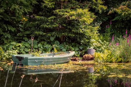 Fishing boat on the lake in the garden with green plants.の写真素材