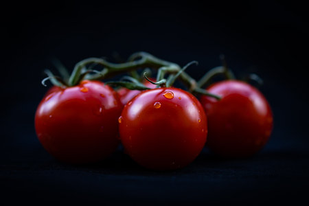 Ripe red cherry tomatoes on a black background. Toned.の写真素材