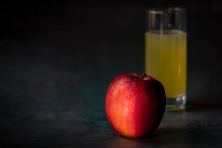 Red apple and a glass of juice on a dark background. Copy space.の写真素材