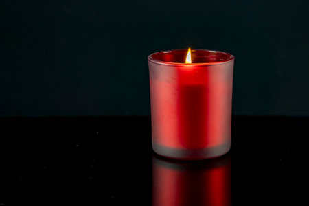 Red candle on a black background, close-up, selective focusの写真素材