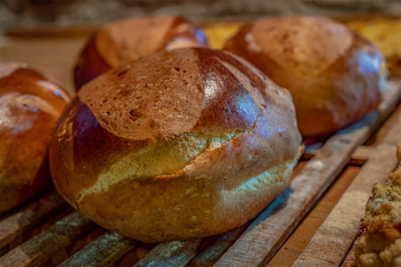 Freshly baked bread rolls on a rustic wooden table in a bakery