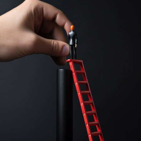 Businessman hand placing red wooden man doll on top of ladder on black backgroundの素材