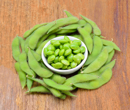 Fresh green peas in bowl on woodenの写真素材