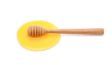 honey with honey stick isolated on white backgroundの写真素材