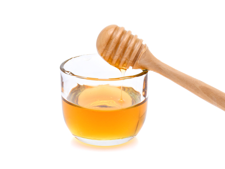 honey with honey stick isolated on white backgroundの写真素材