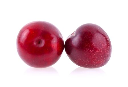 Red cherry plum with green leaves isolated on whiteの写真素材