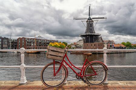 Red bike in front of the Molen De Adriaan in Haarlemの写真素材