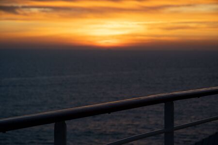 Railing of a cruise ship in the sunset