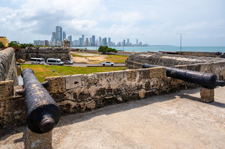 The city wall and a cannon, pointing to a modern neighborhood of Cartagena.