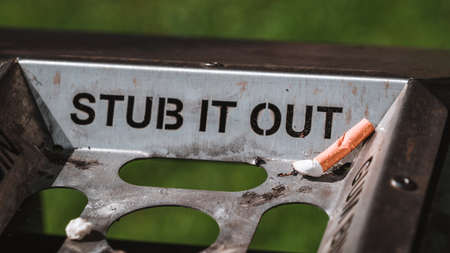 Stub it out - close up of a cigarette stub on a waste binの写真素材