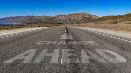 Change Ahead with arrow written on highway road to the mountainの写真素材