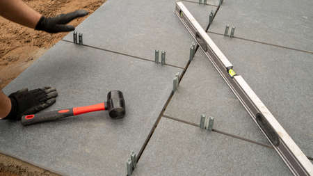 Expert workman laying patio slabs in garden makeoverの写真素材
