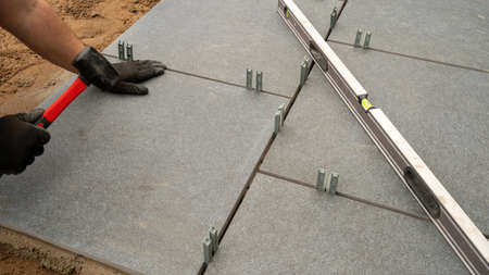 Expert workman laying patio slabs in garden makeoverの写真素材
