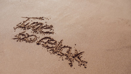 Time to relax written in the sand on the beachの写真素材