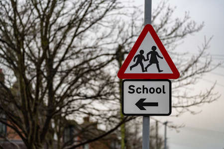 School crossing sign on a lamppost against a winter skyの写真素材